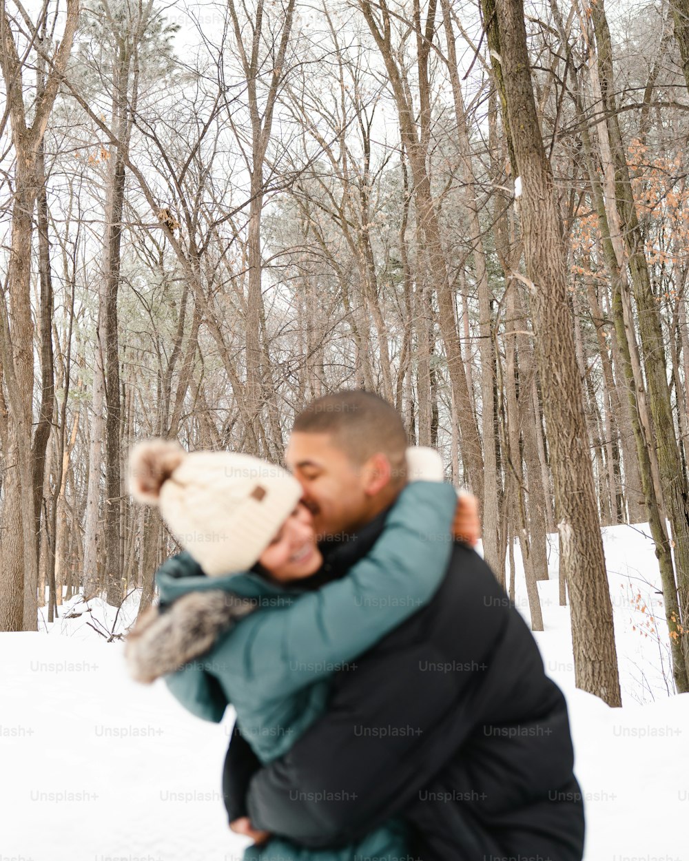 a man and a woman hugging in the snow