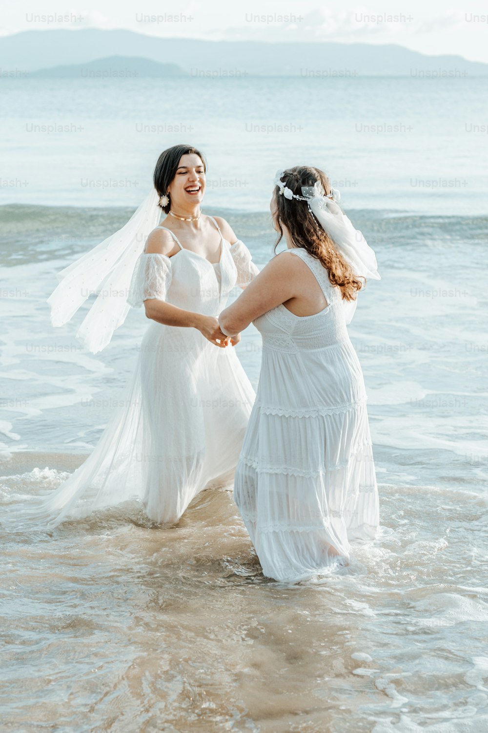 um casal de mulheres de pé um ao lado do outro no oceano