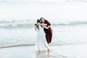 Una coppia di donne in piedi sulla cima di una spiaggia
