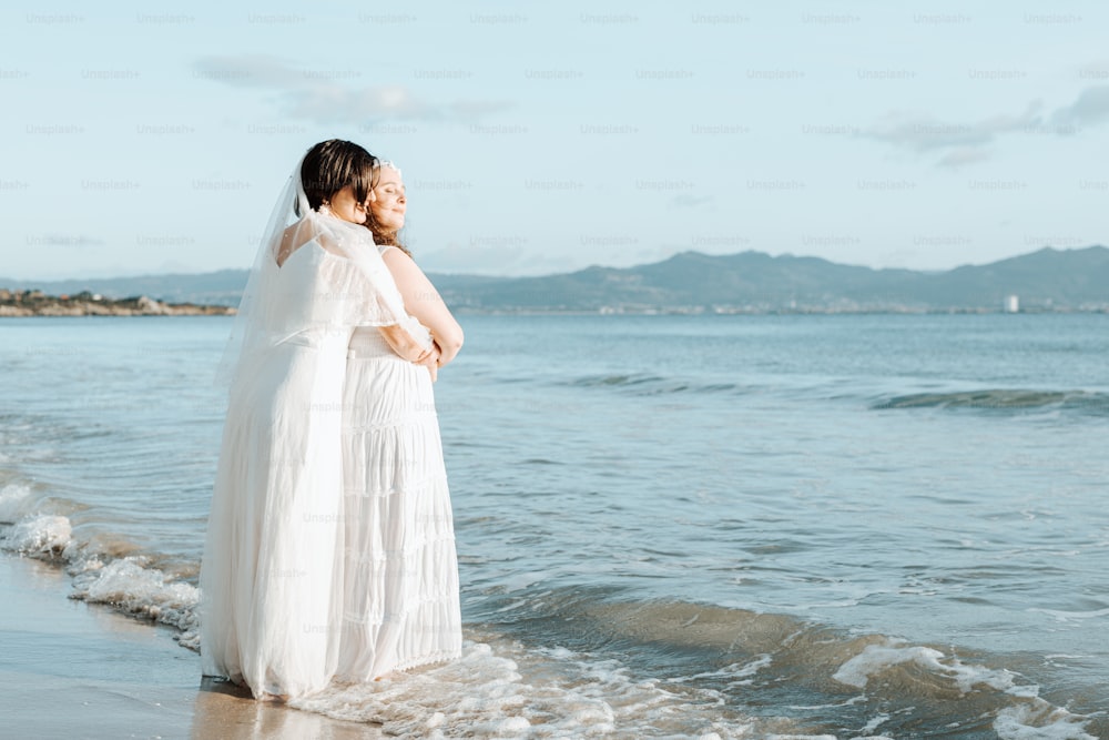 uma mulher em um vestido branco em pé em uma praia