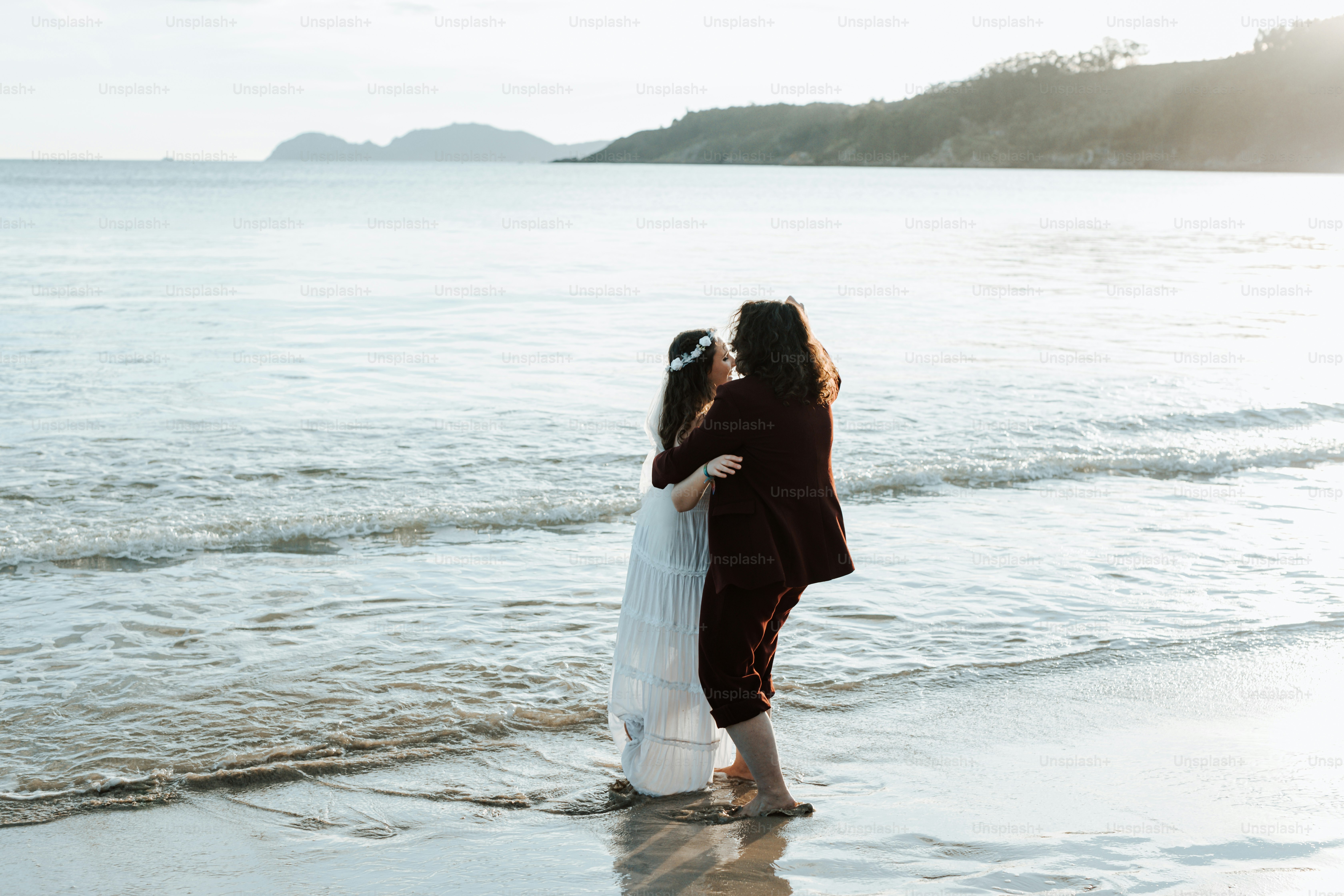 a couple of women standing on top of a beach