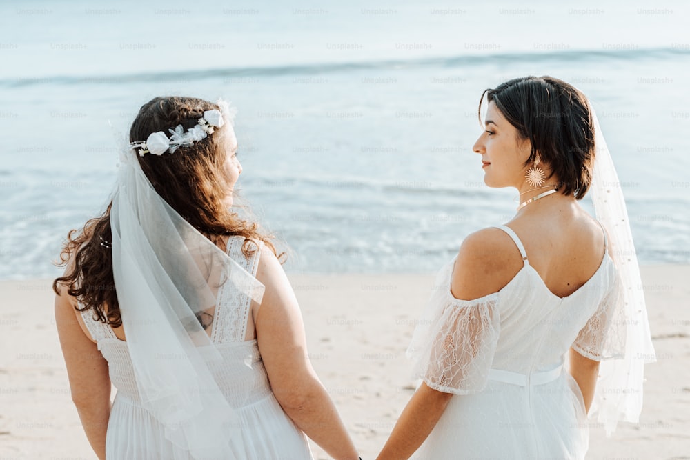 a couple of women standing next to each other on a beach