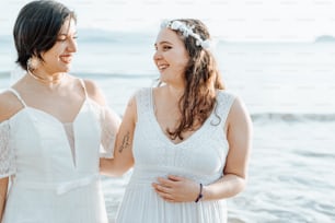 a couple of women standing next to each other on a beach