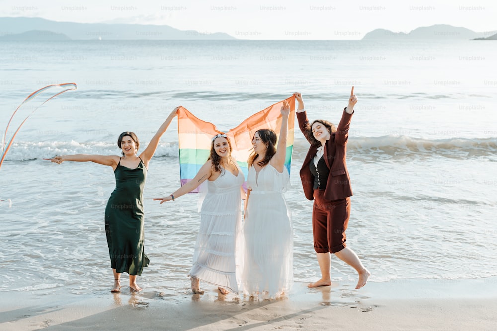 a group of women standing next to each other on a beach