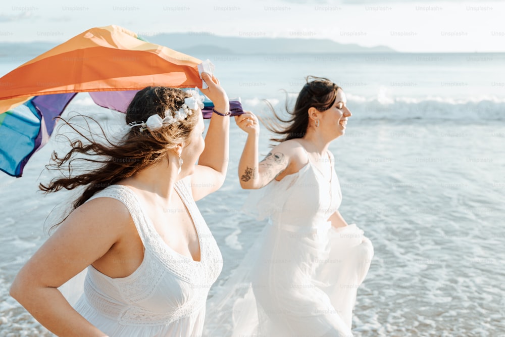 a couple of women standing next to each other on a beach