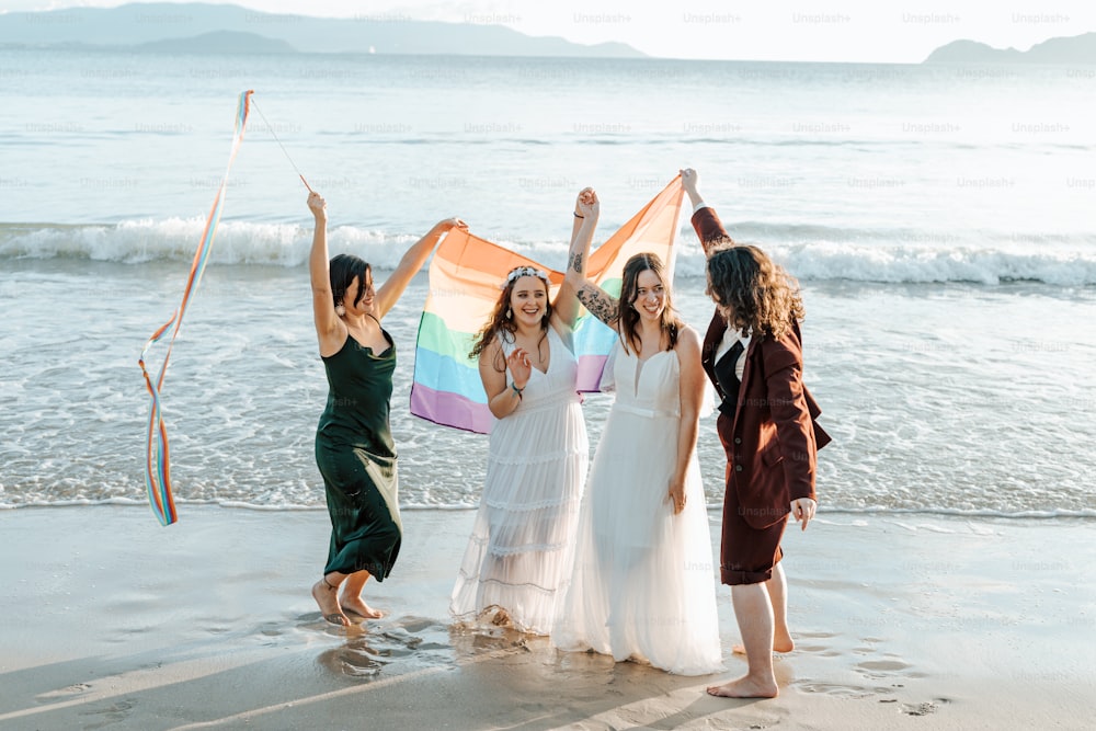 um grupo de mulheres em pé no topo de uma praia de areia