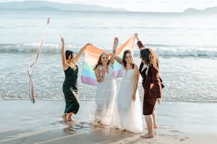 a group of women standing on top of a sandy beach