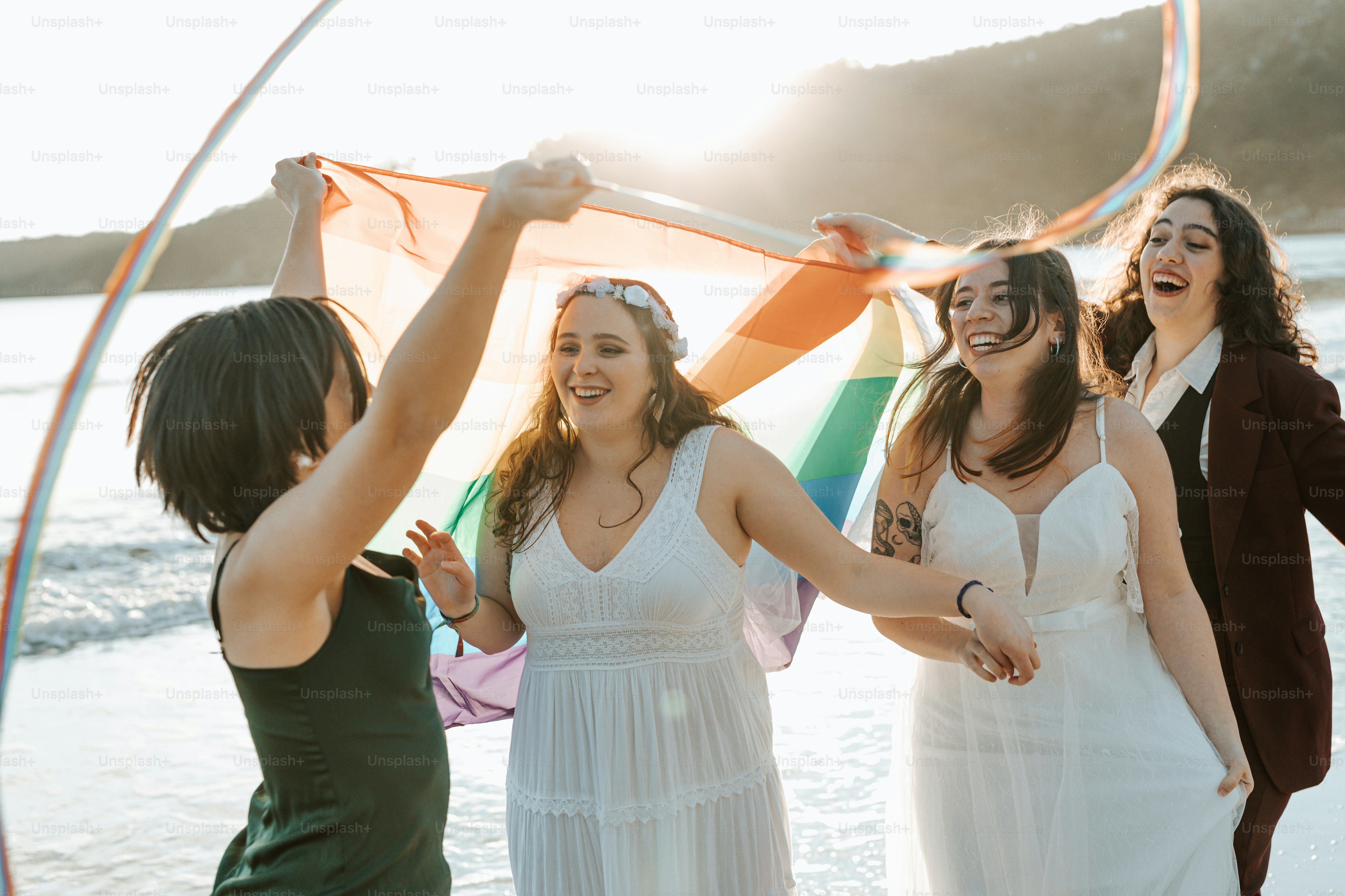 a group of women standing next to each other on a beach