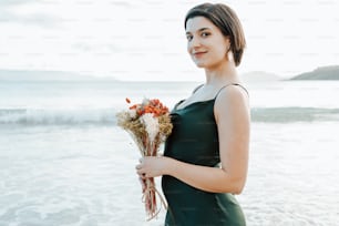 a woman in a green dress holding a bouquet of flowers