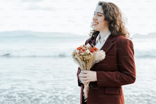 a woman in a suit holding a bouquet of flowers