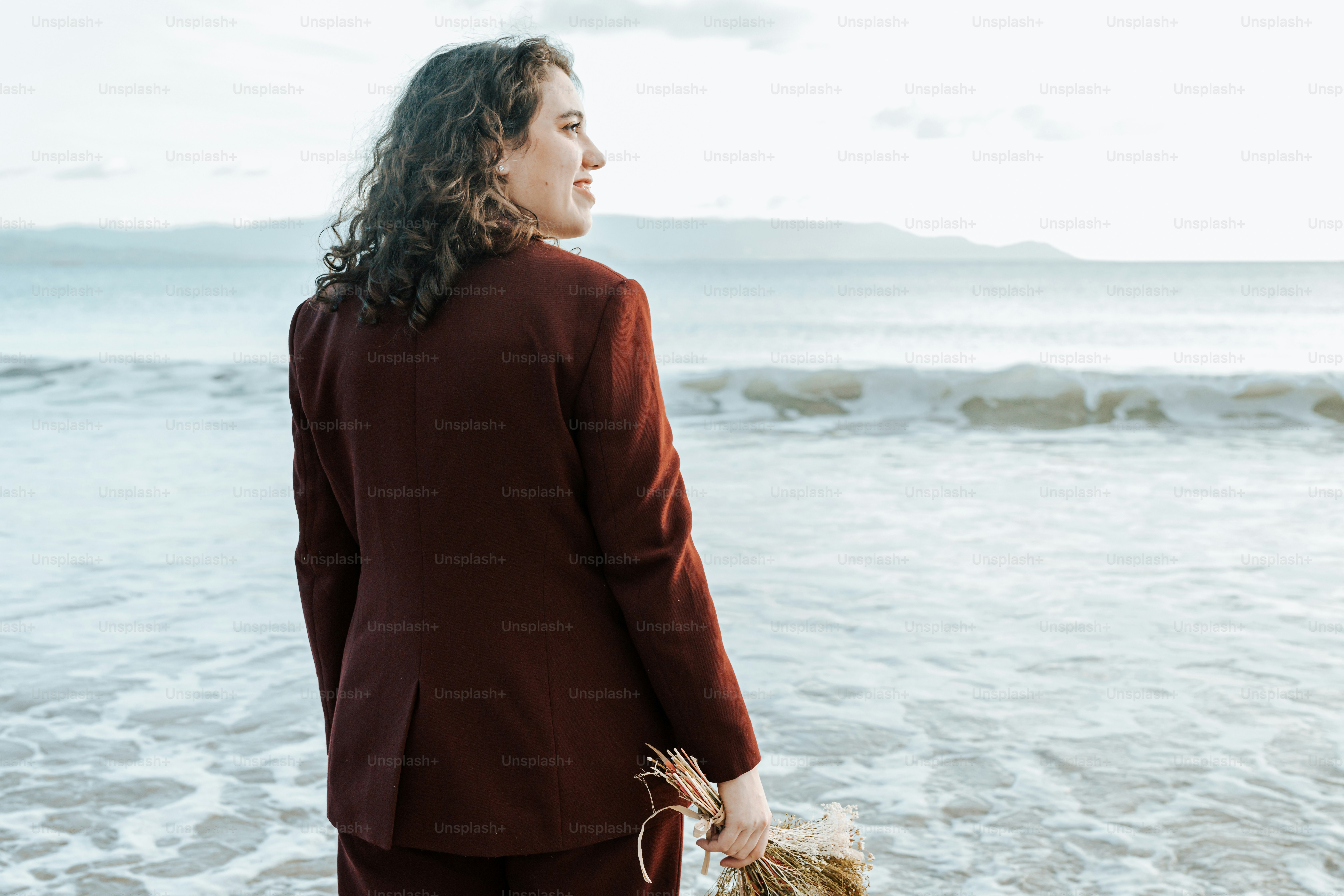 Una mujer con un traje rojo parada en la playa