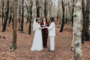 a bride and groom standing in the woods during their wedding ceremony