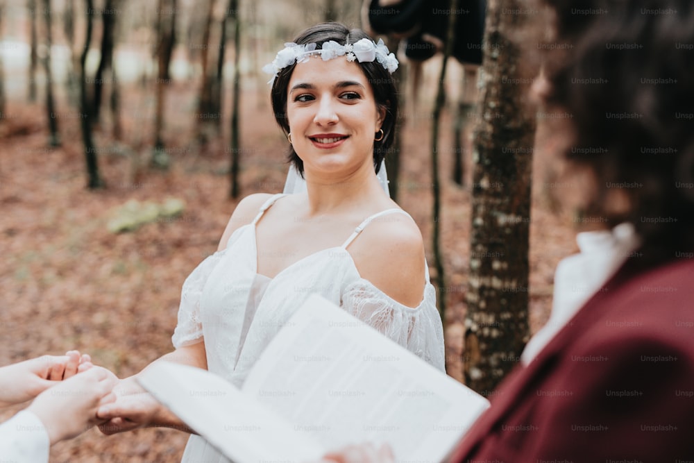 a woman in a white dress holding a book