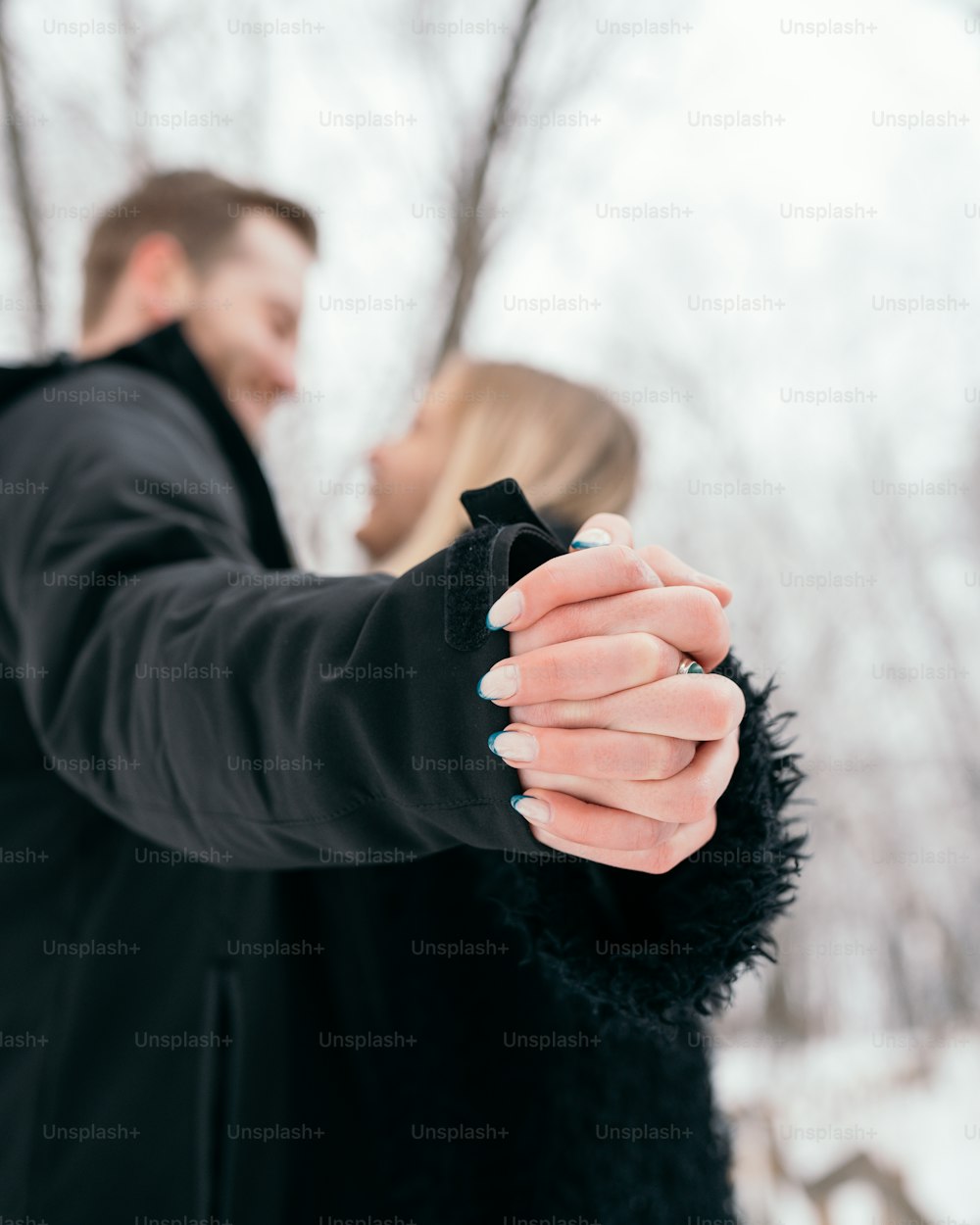 um homem e uma mulher de mãos dadas na neve