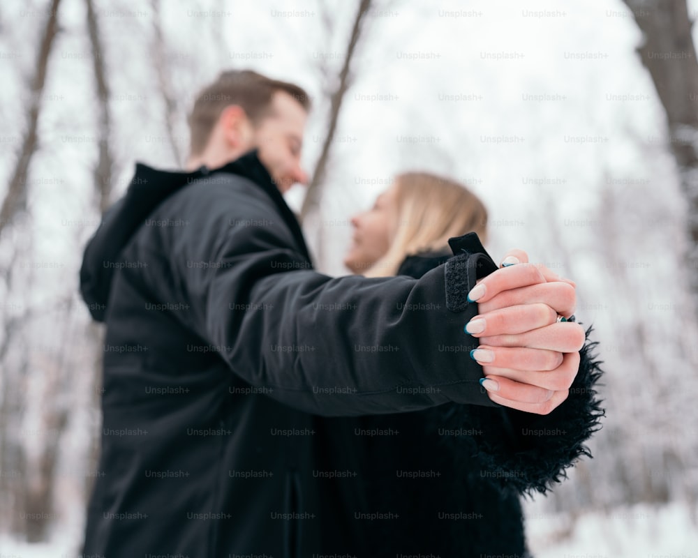 um homem e uma mulher de mãos dadas na neve