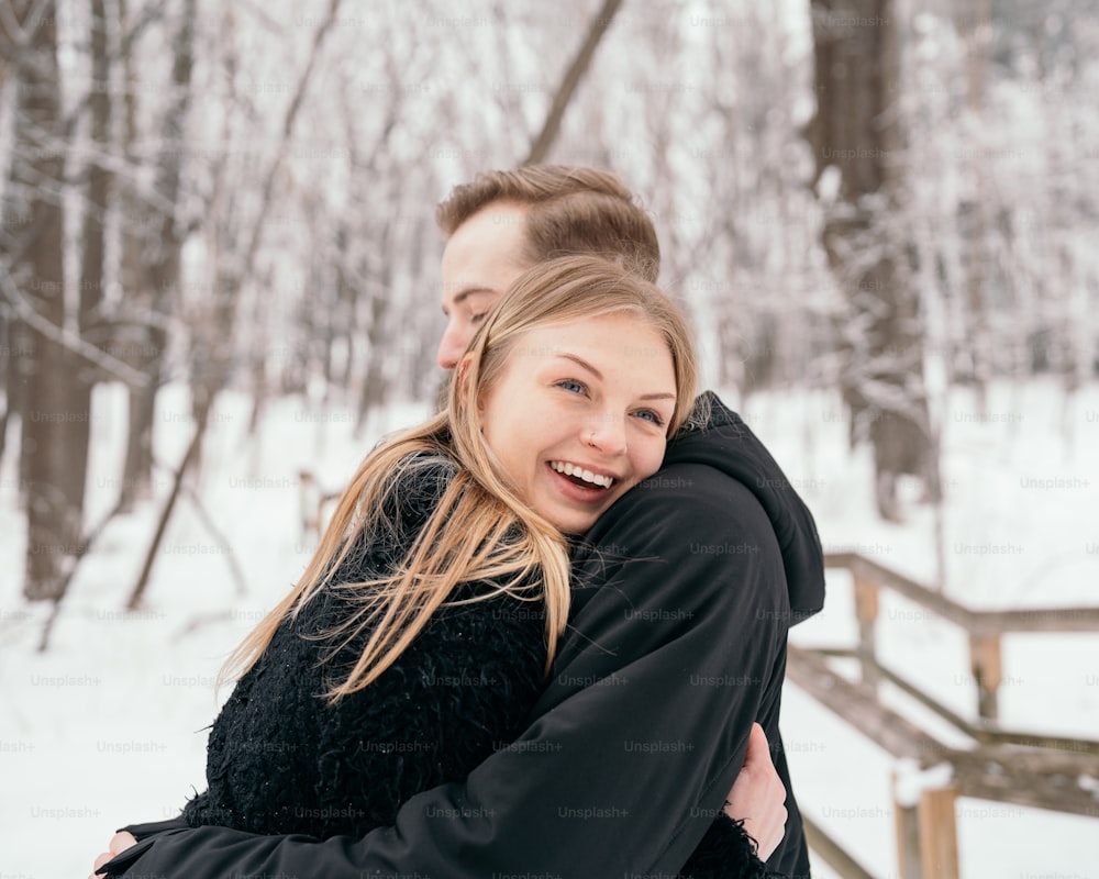 a man hugging a woman in the snow