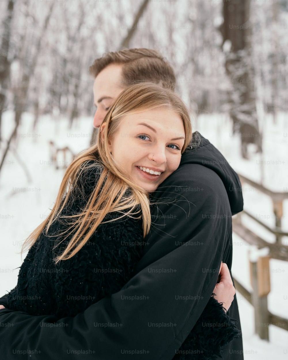 um homem abraçando uma mulher na neve