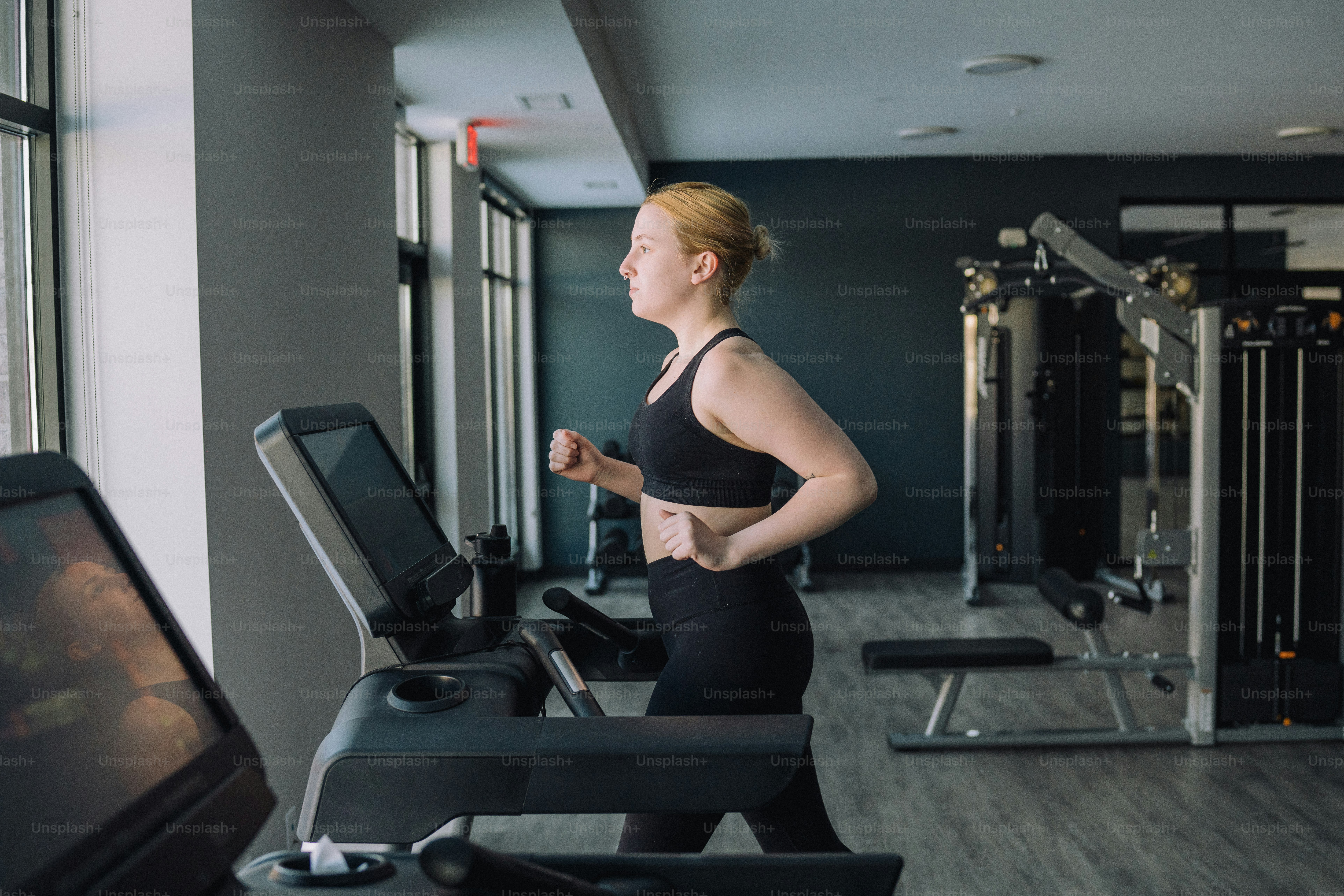 a woman running on a treadmill in a gym