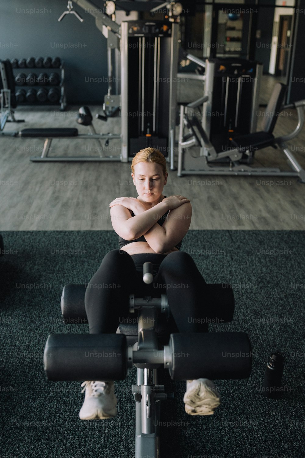 une femme assise sur un banc dans un gymnase