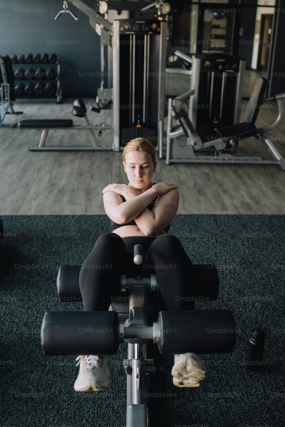 a woman sitting on a bench in a gym