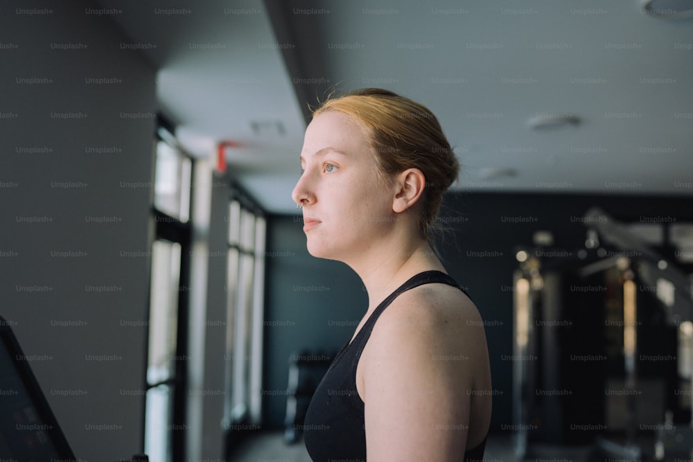 a woman standing in a gym looking off into the distance