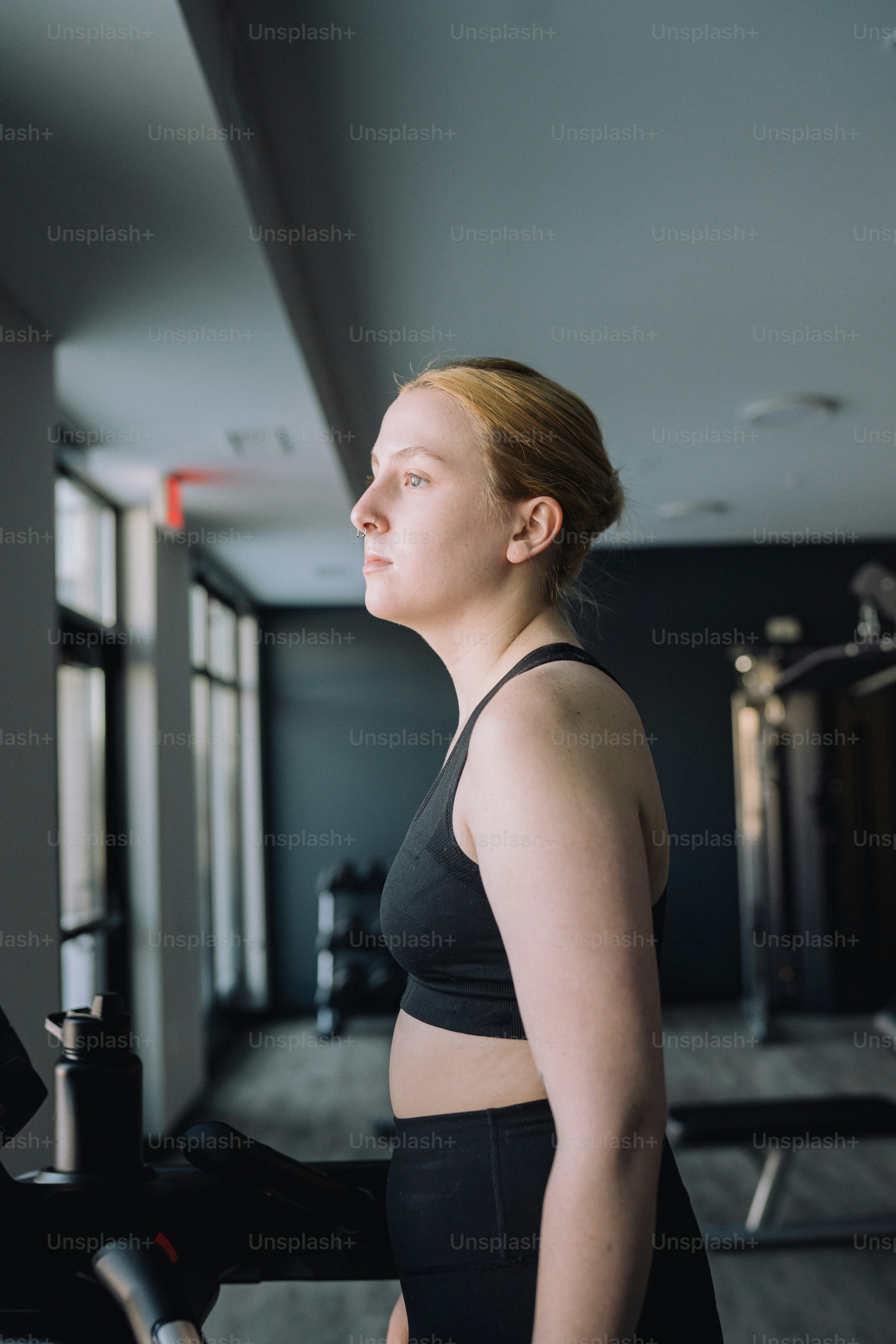 a woman in a black sports bra standing in a gym