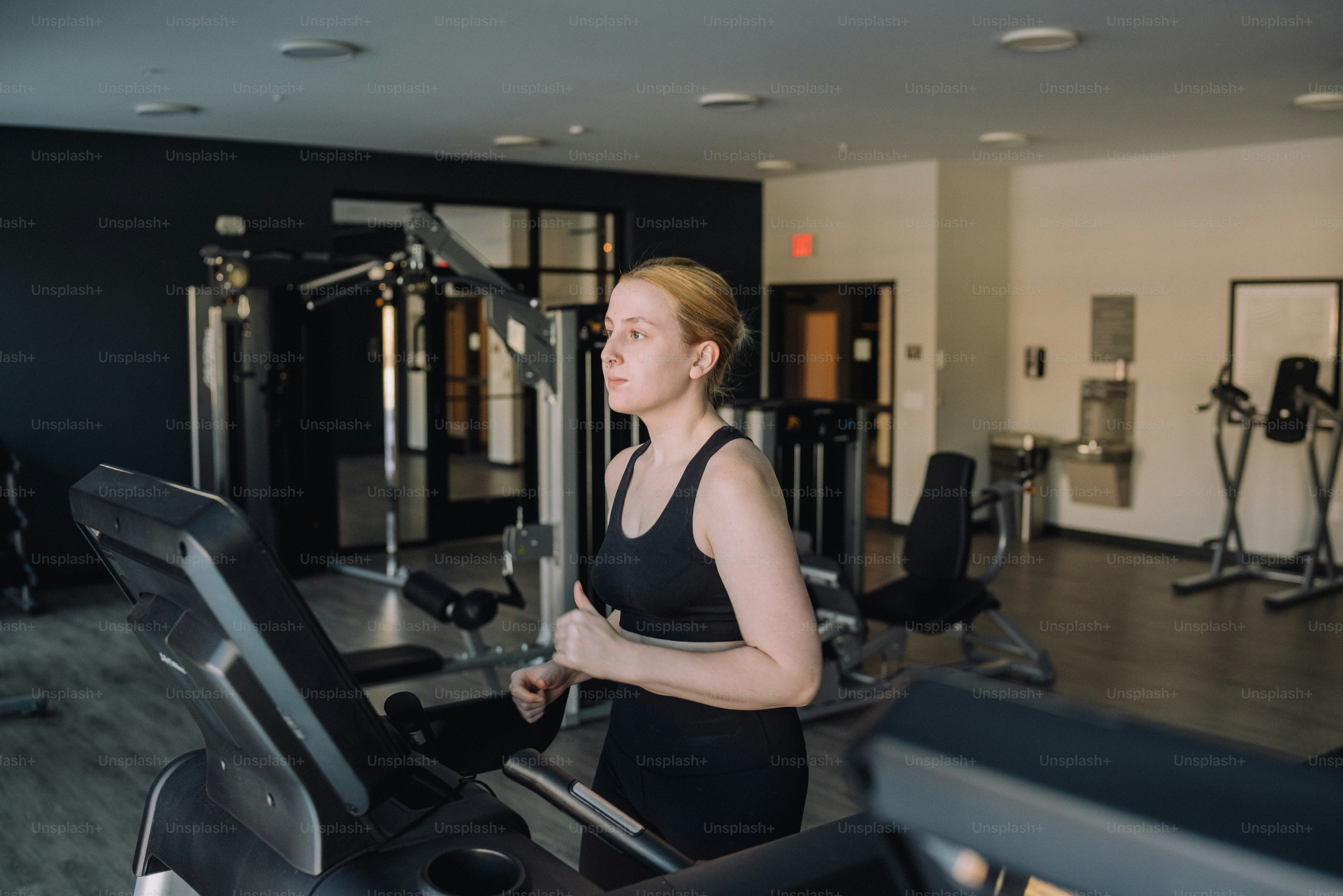 a woman is running on a treadmill in a gym