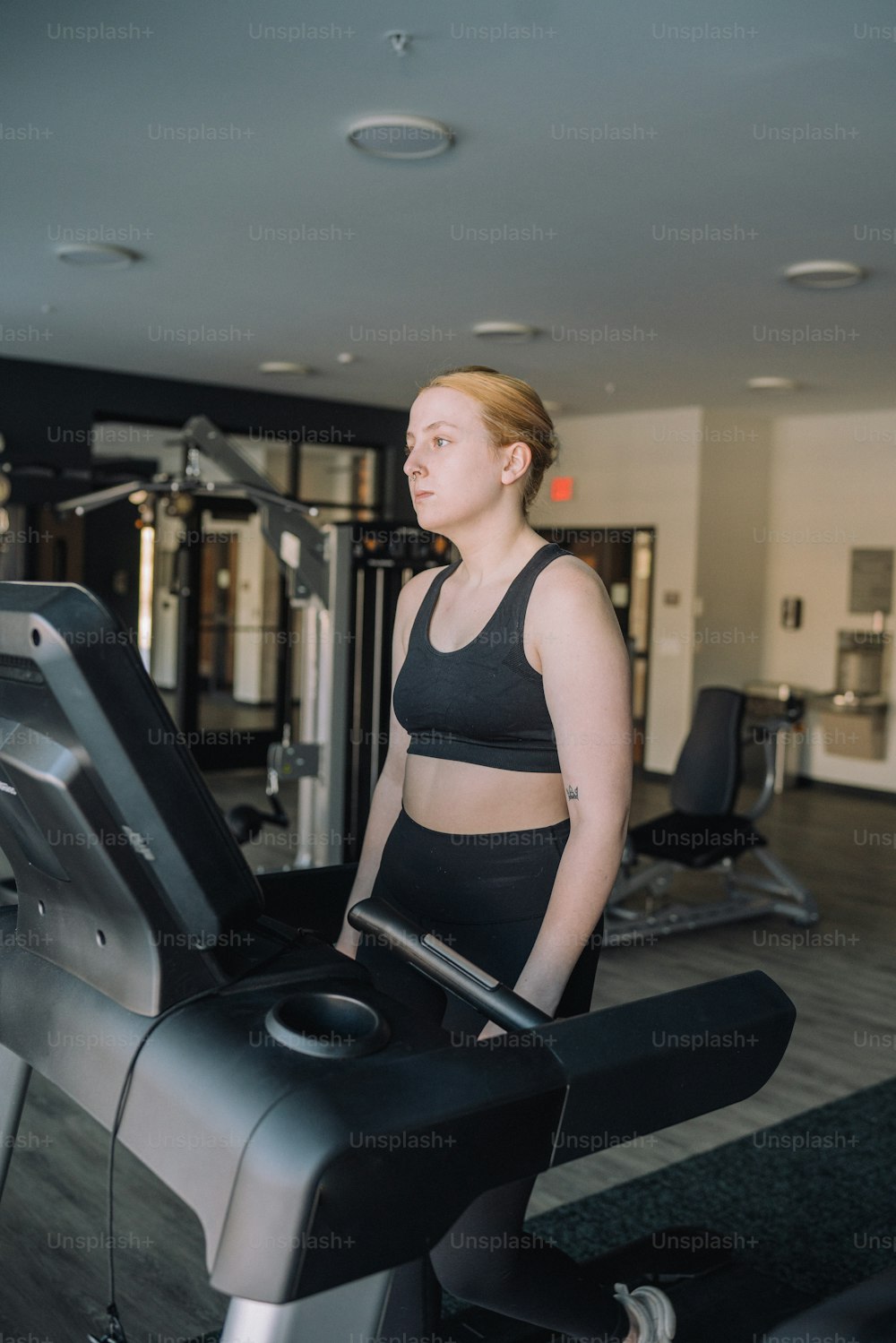 a woman standing on a treadmill in a gym
