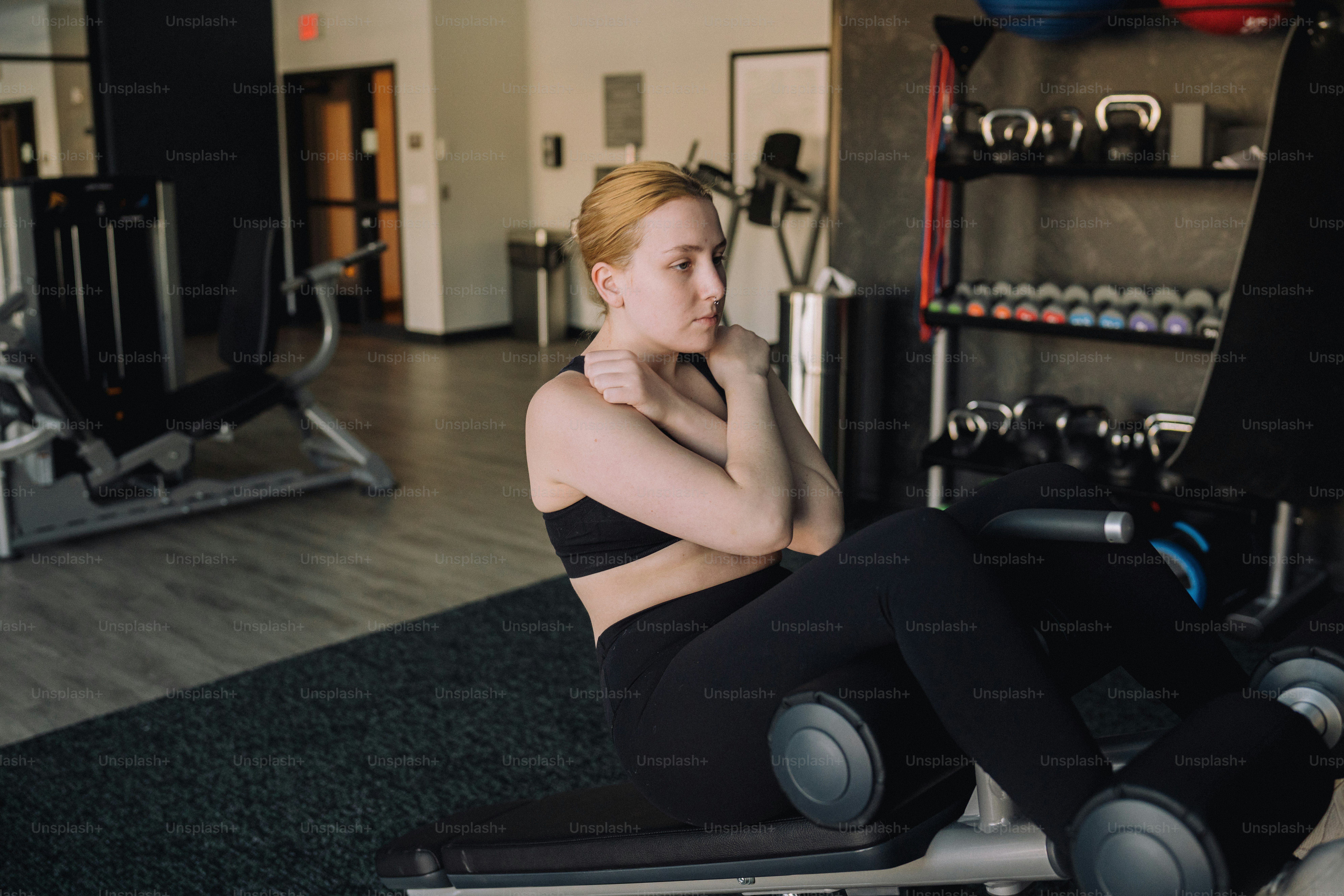 a woman sitting on a bench in a gym