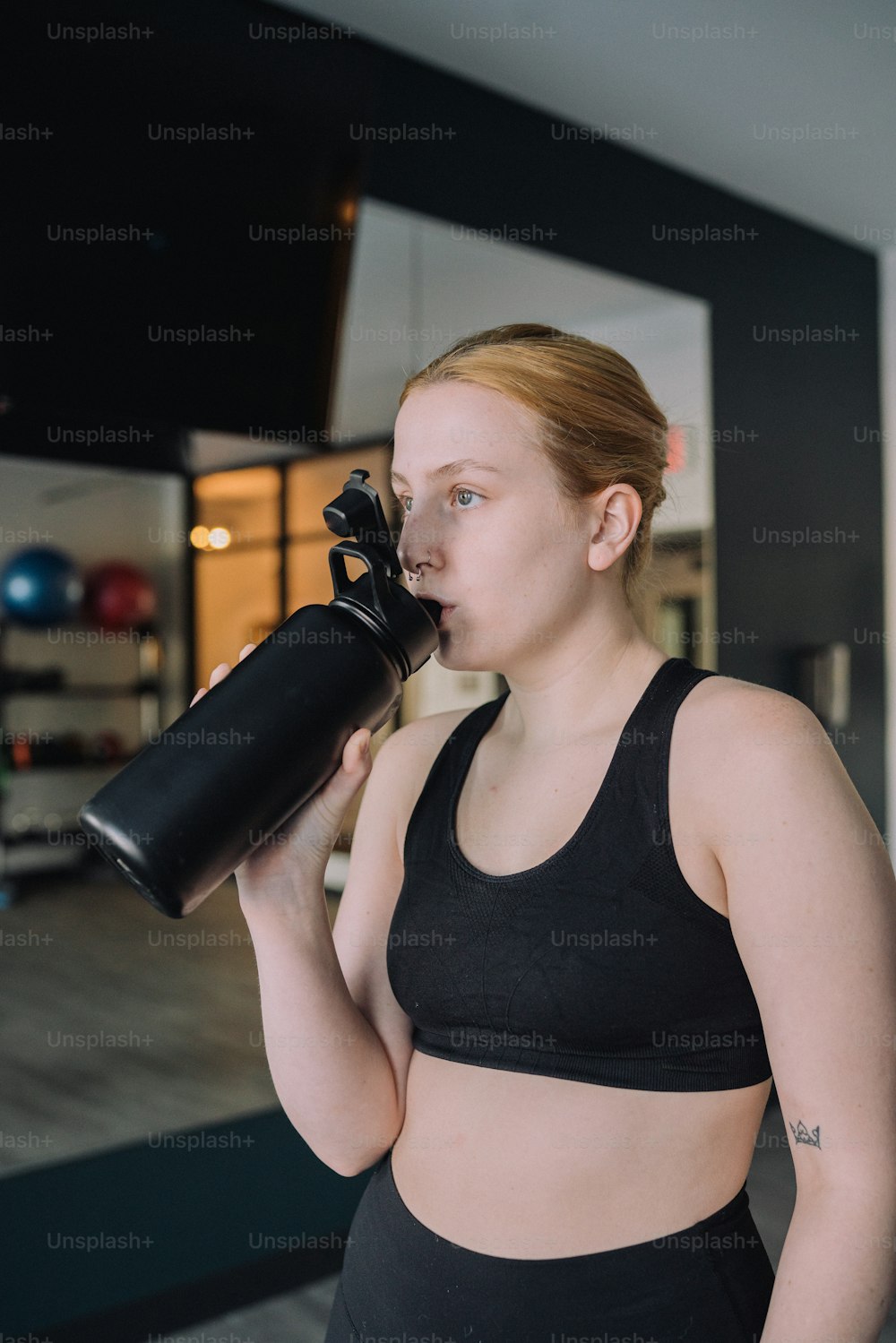 a woman in a sports bra holding a gym equipment