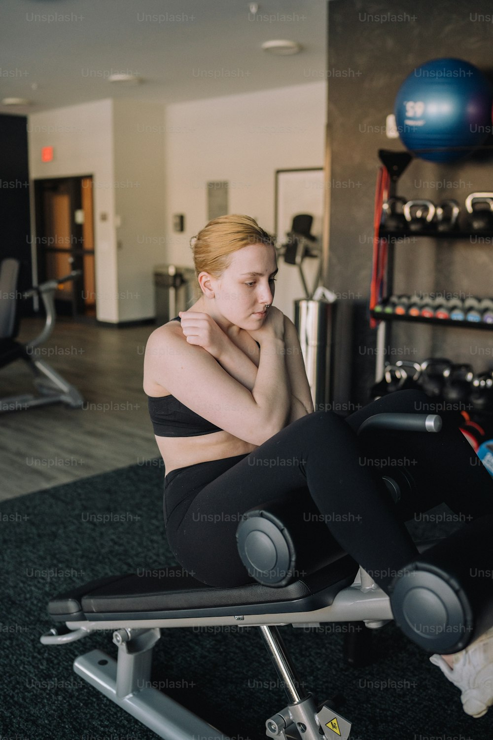 a woman sitting on a bench in a gym