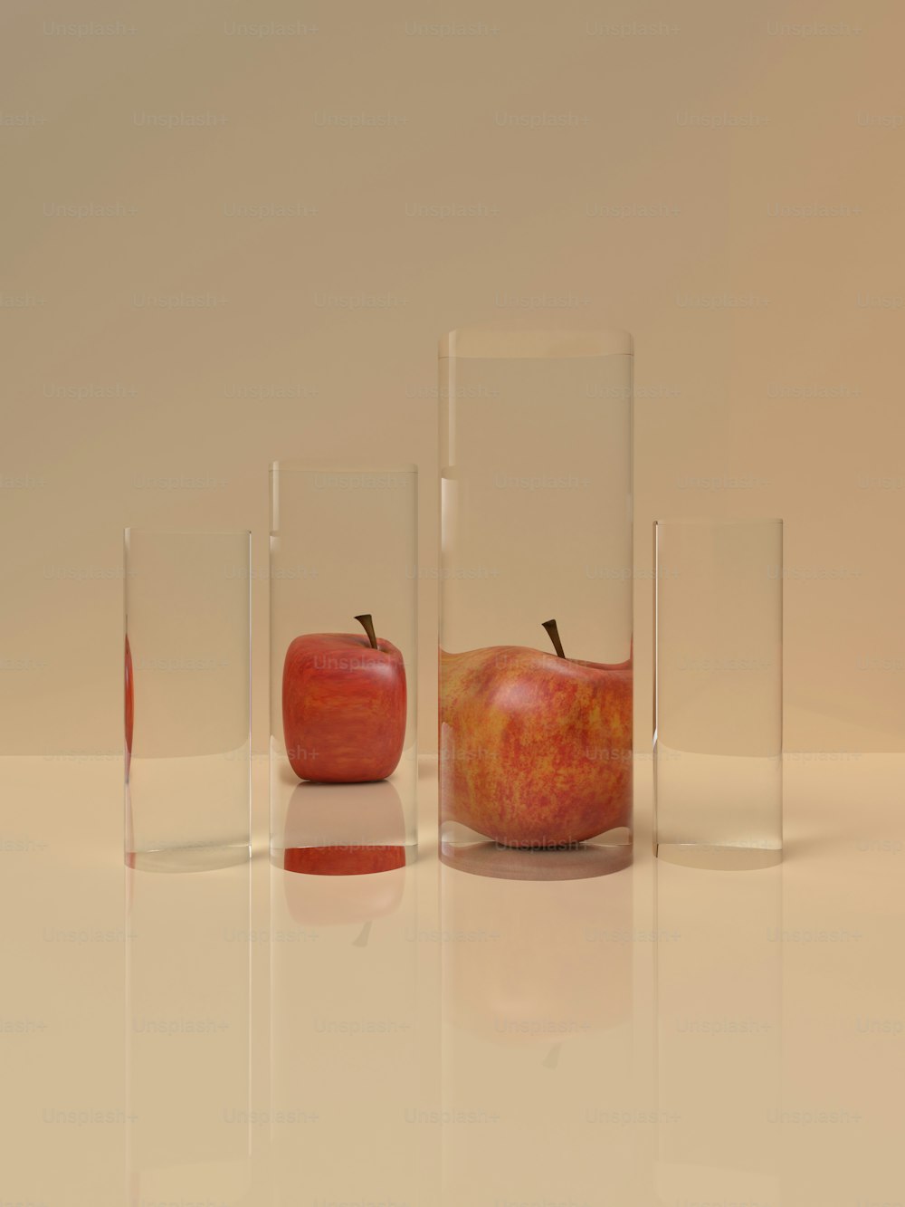 a group of three glass vases with apples in them