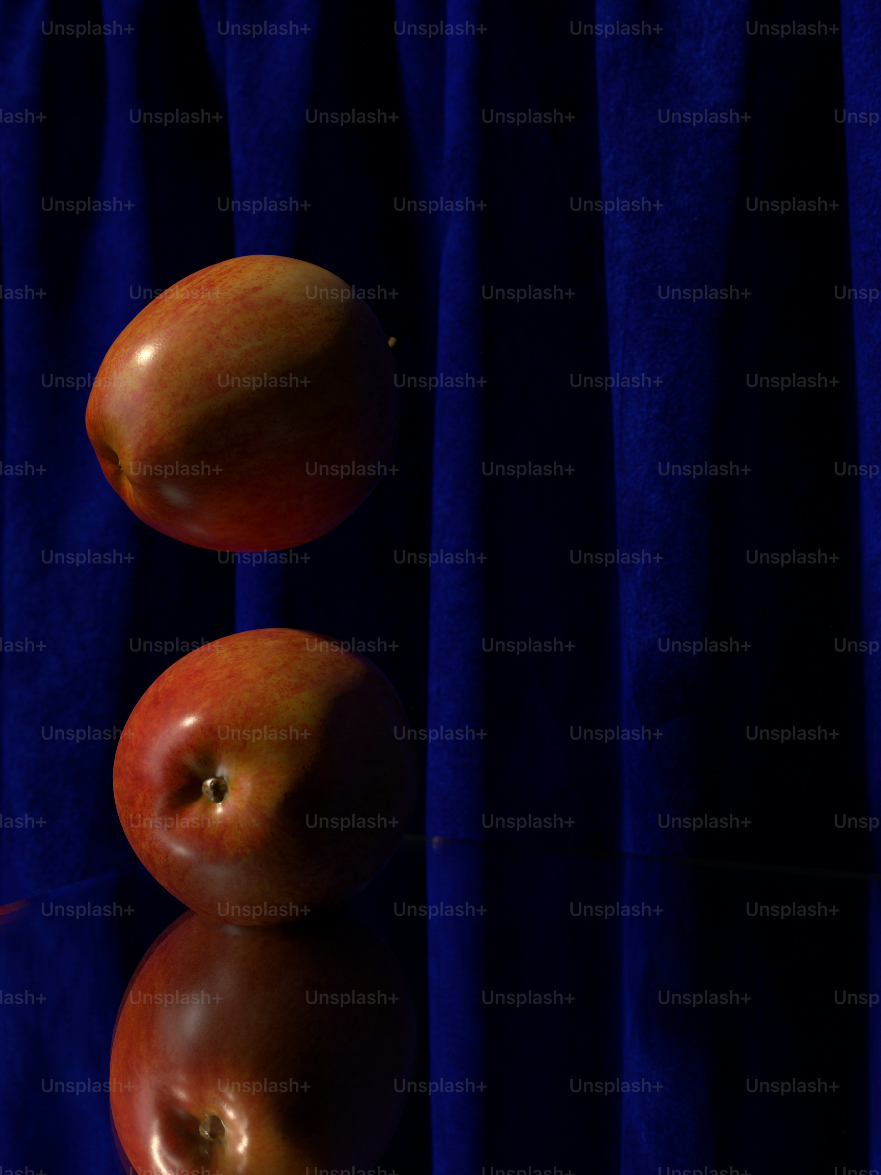 um par de maçãs sentadas em cima de uma mesa