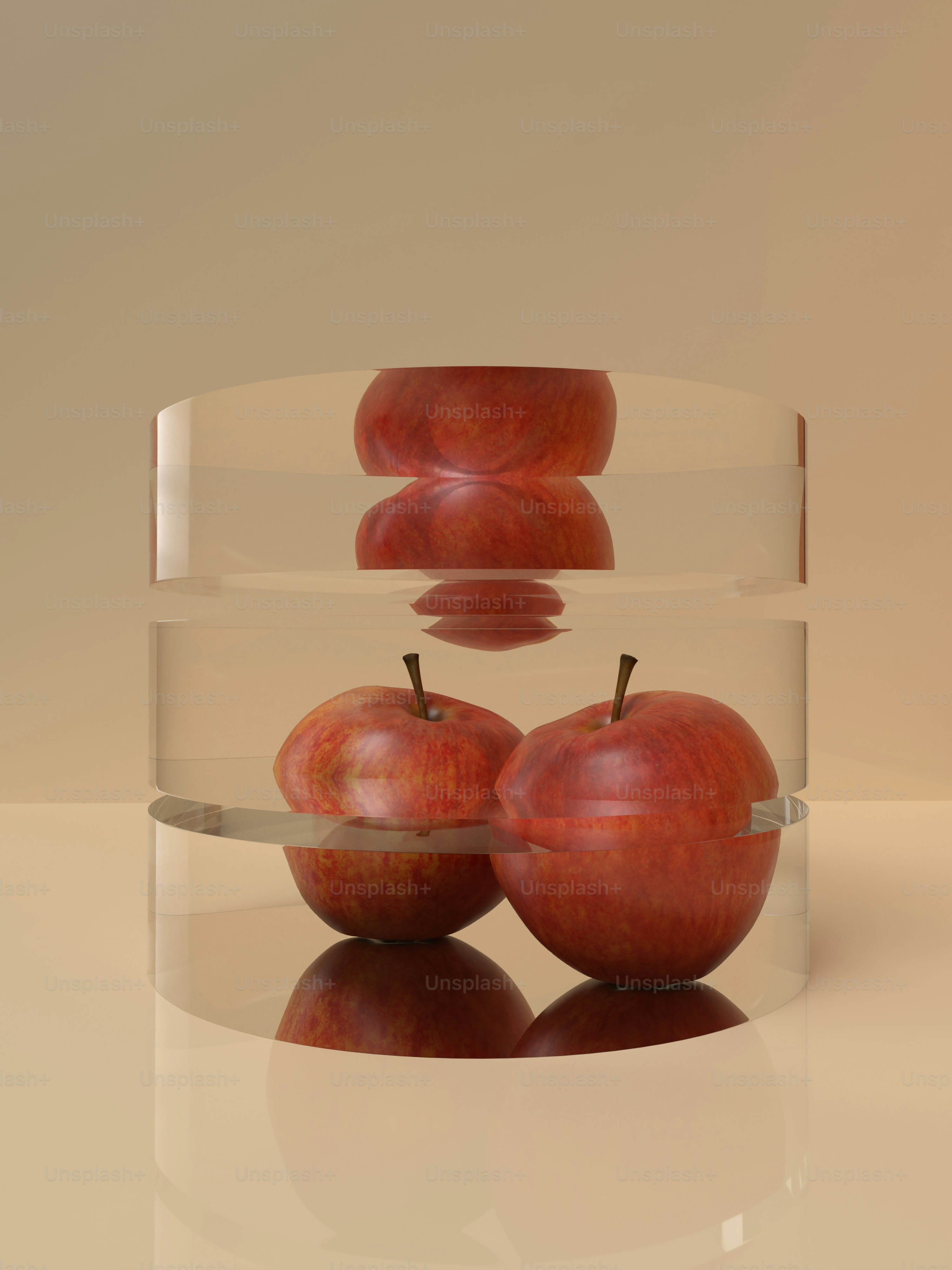 three red apples in a clear bowl on a white surface