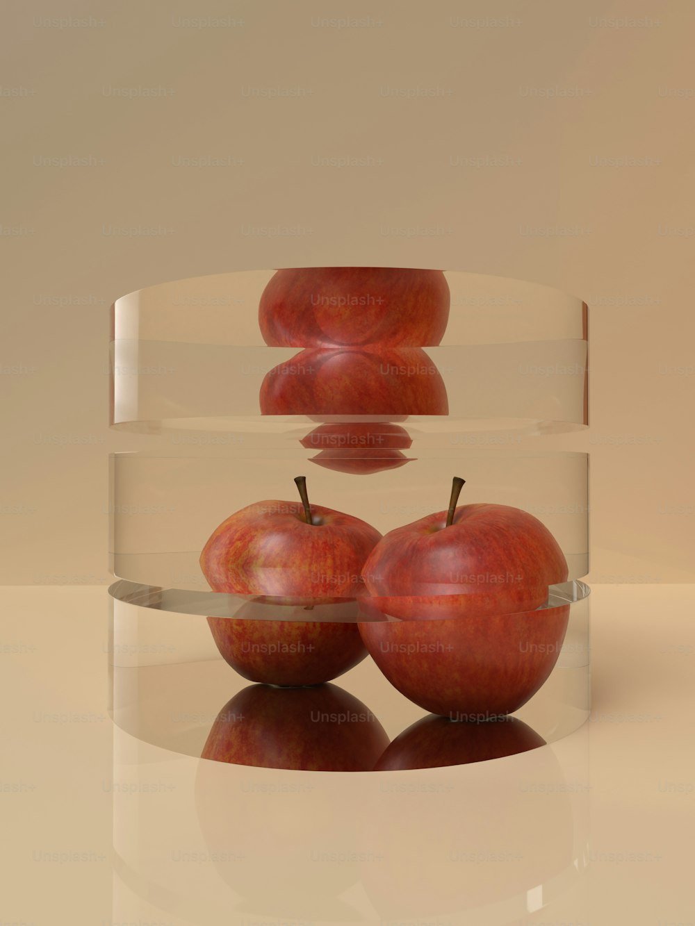 Tres manzanas rojas en un tazón transparente sobre una superficie blanca