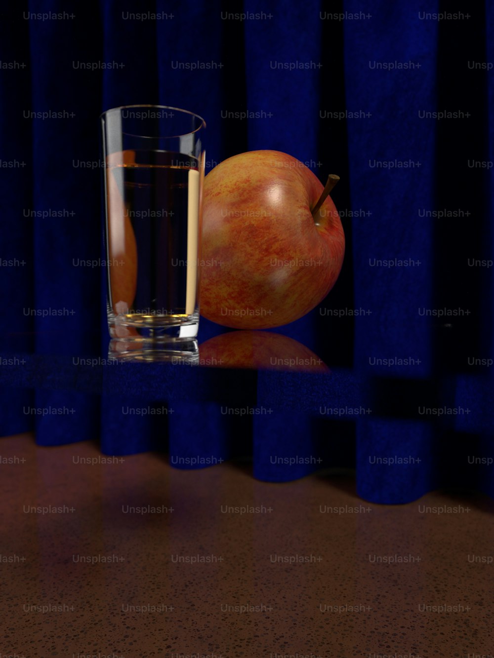a glass of water and an apple on a table