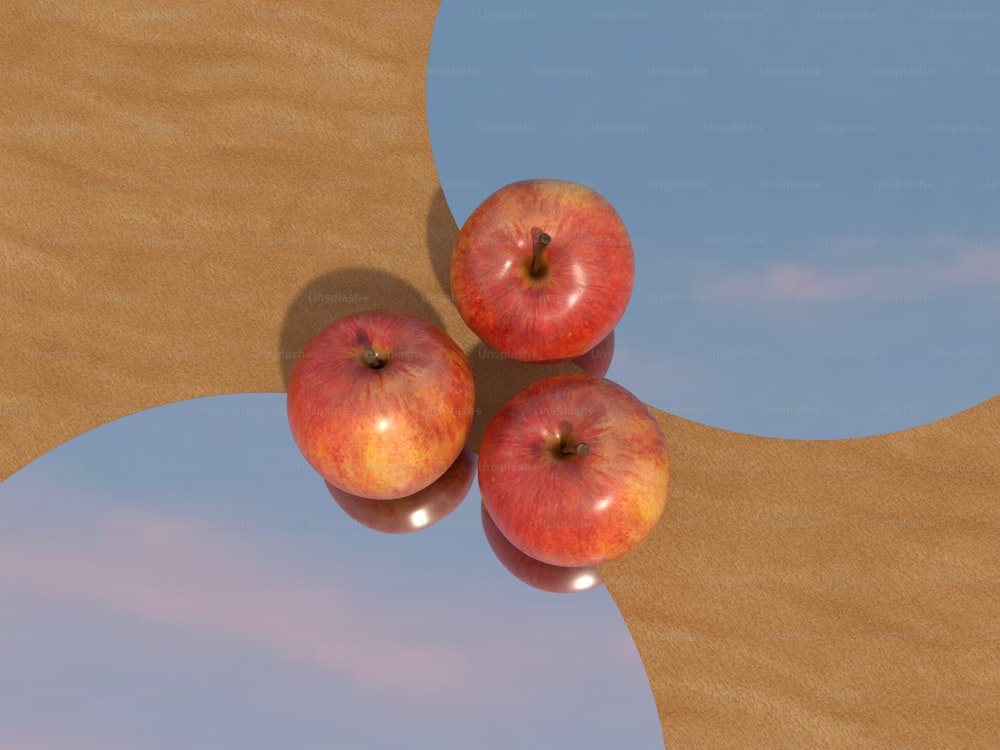 Tres manzanas sentadas una encima de la otra en una mesa