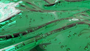 un primer plano de un líquido verde con gotas de agua sobre él