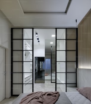 a bedroom with a bed and a mirrored wall