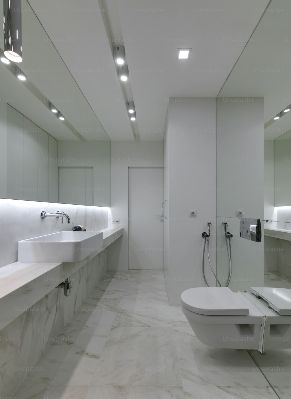 a bathroom with a toilet, sink, and mirror