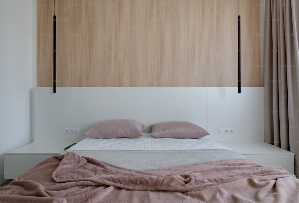 un letto con piumino rosa e cuscini