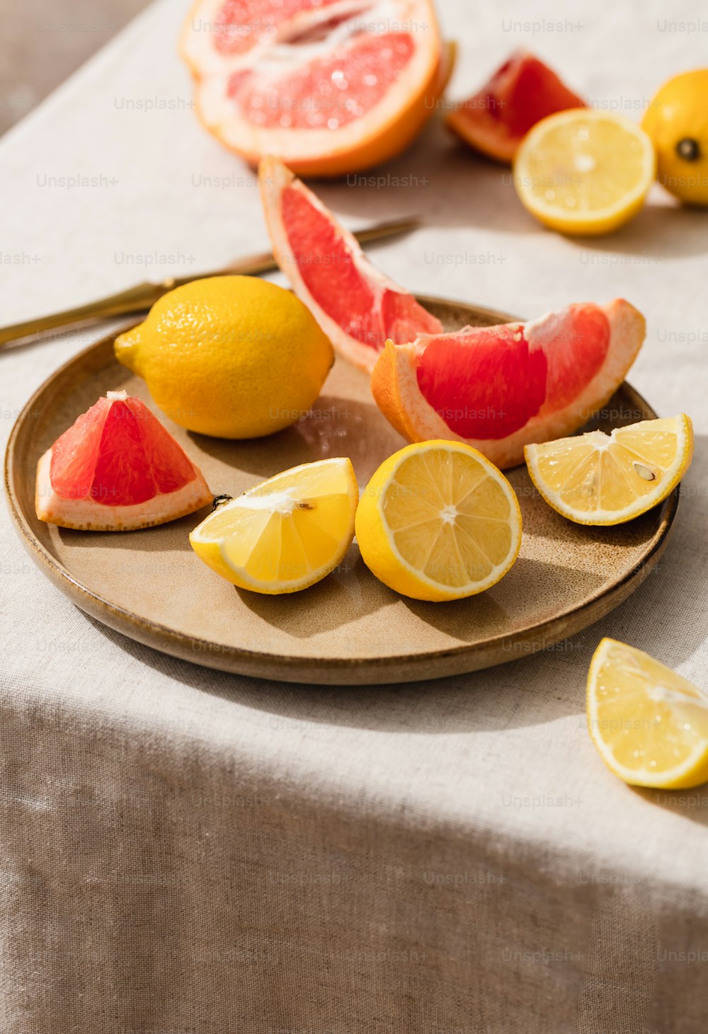 a plate full of sliced up lemons and grapefruits