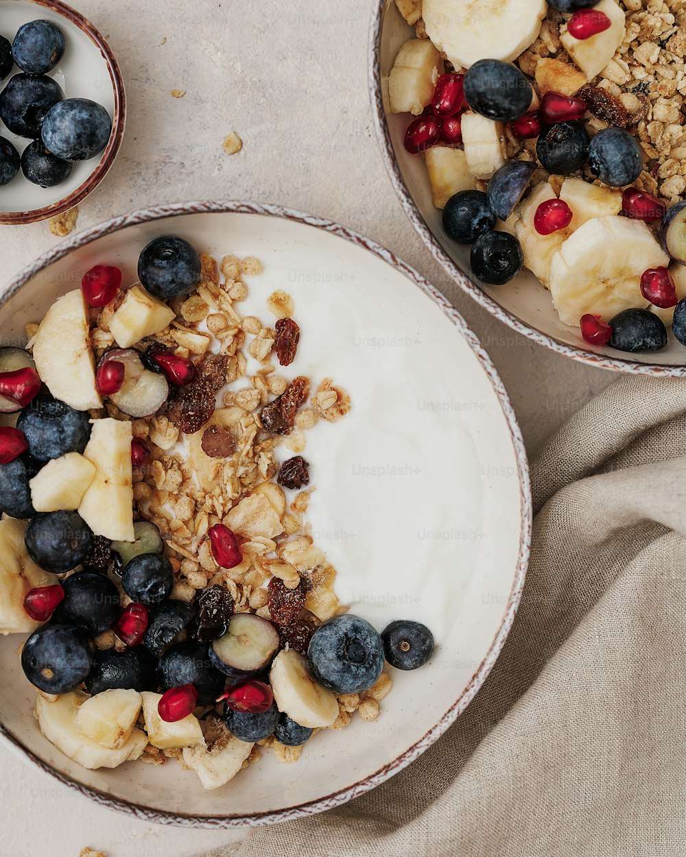 a bowl of granola and a bowl of fruit on a table
