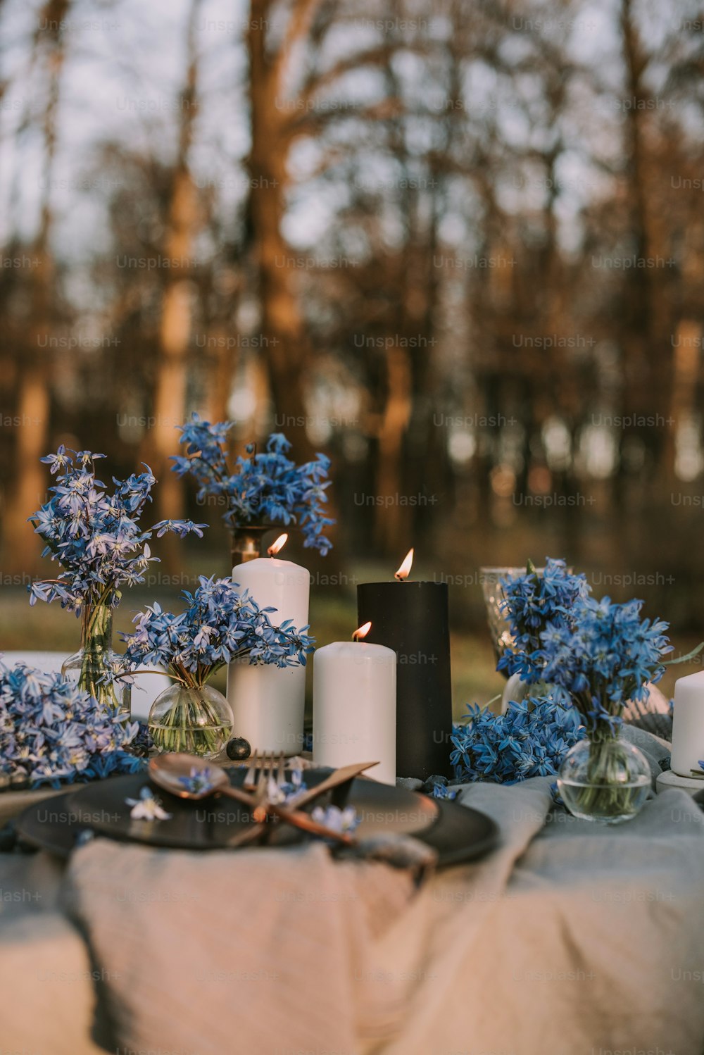 a table topped with blue flowers and candles