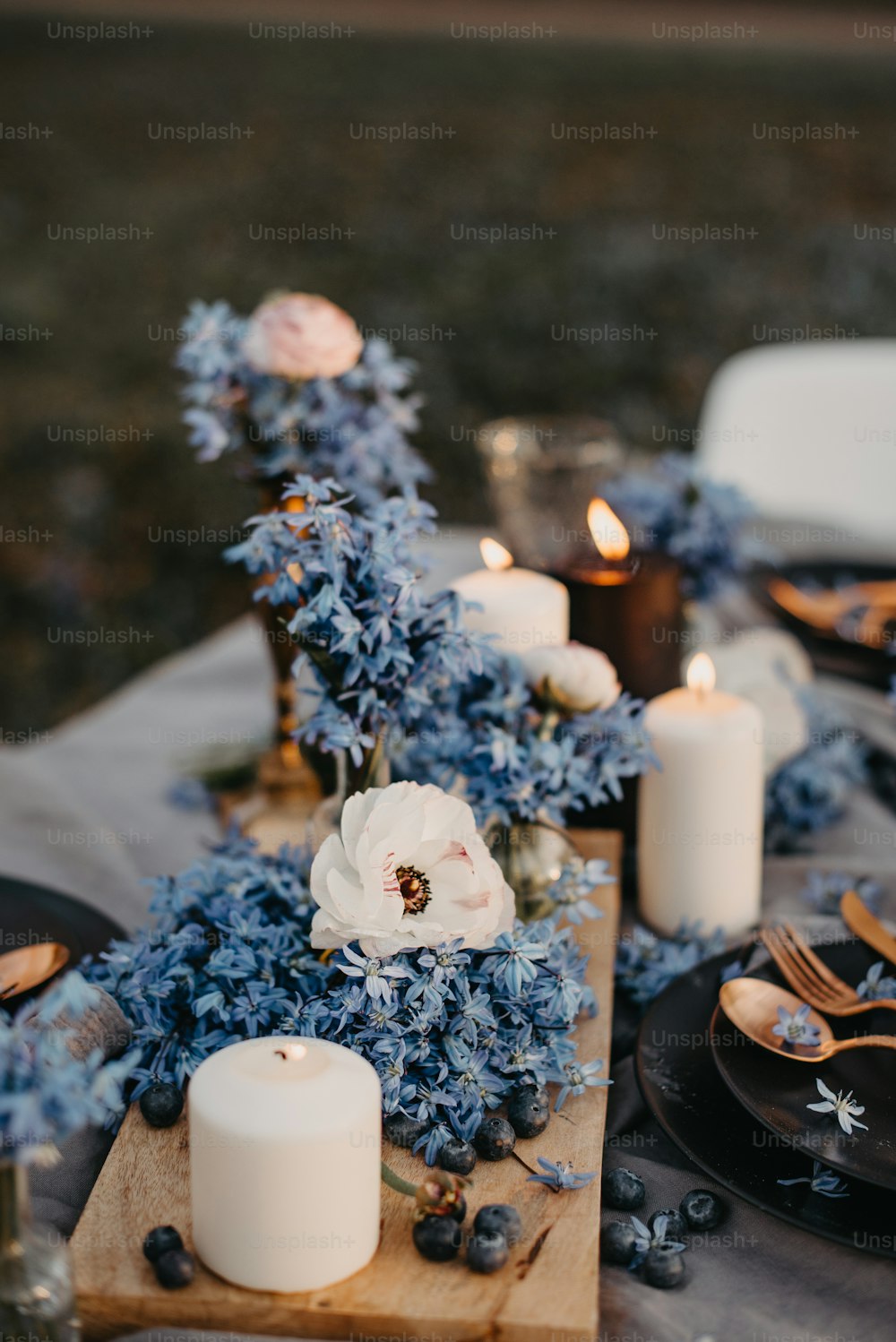 uma mesa coberta com flores azuis e velas