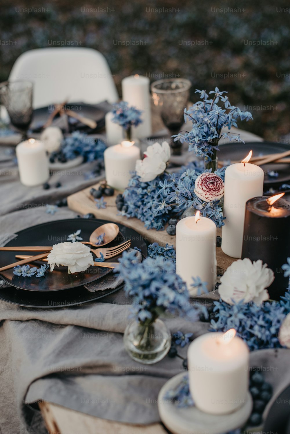 Una mesa cubierta con muchas flores blancas y azules
