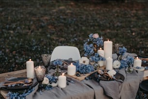 uma mesa coberta com pratos e velas ao lado de um campo