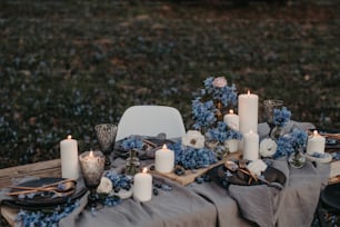 a table topped with plates and candles next to a field