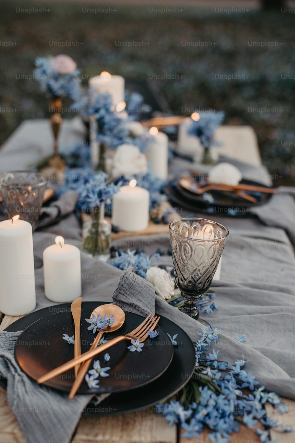 a table topped with a black plate covered in blue flowers