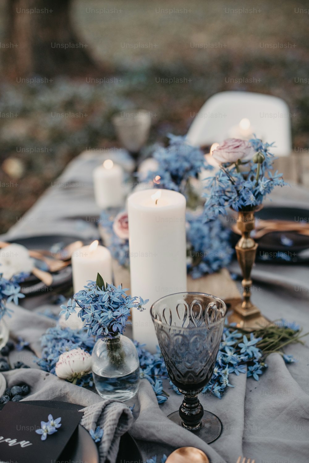 a table topped with blue flowers and candles